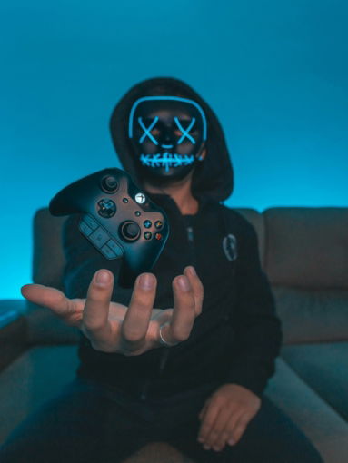 person sitting on chair while holding Xbox One controller
